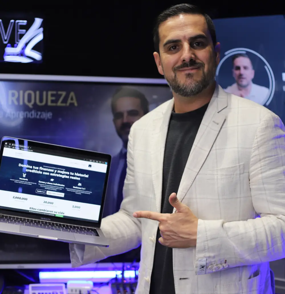 Frank García creador de la mentoría deudas a riquezas mostrando su laptop